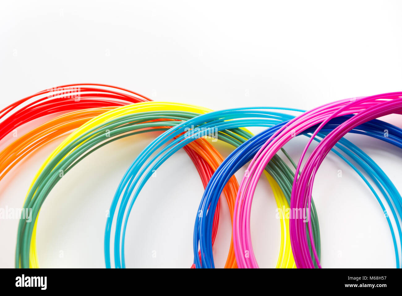 Colorful rainbow plastic filaments with for 3D pen laying on white. New