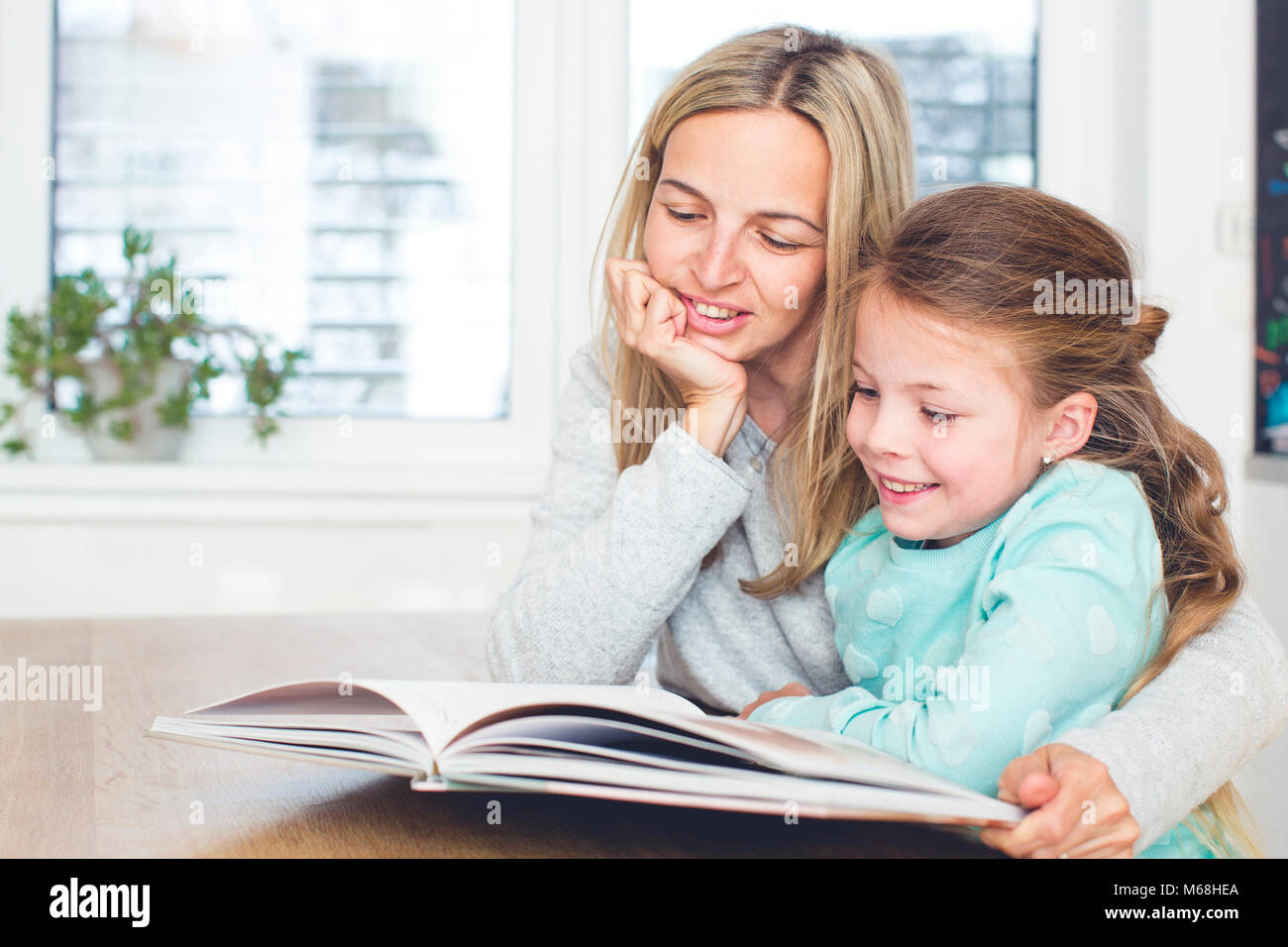 Daughter and m. Мама с дочкой читают. Мама и дочь читают книгу. Мама читает дочке книжку. Фото мама читает с дочкой.