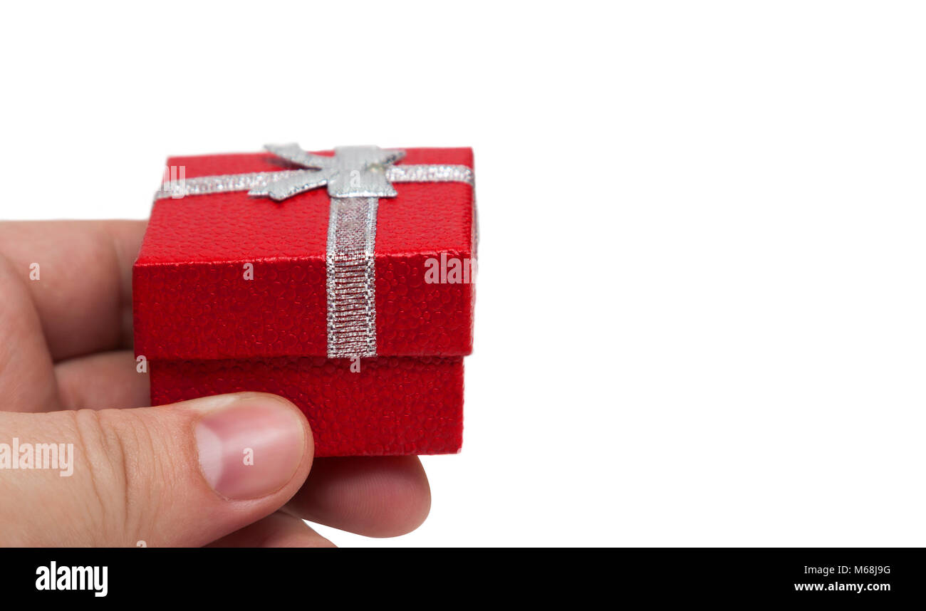 Hand holding small red color gift with silver ribbon Stock Photo