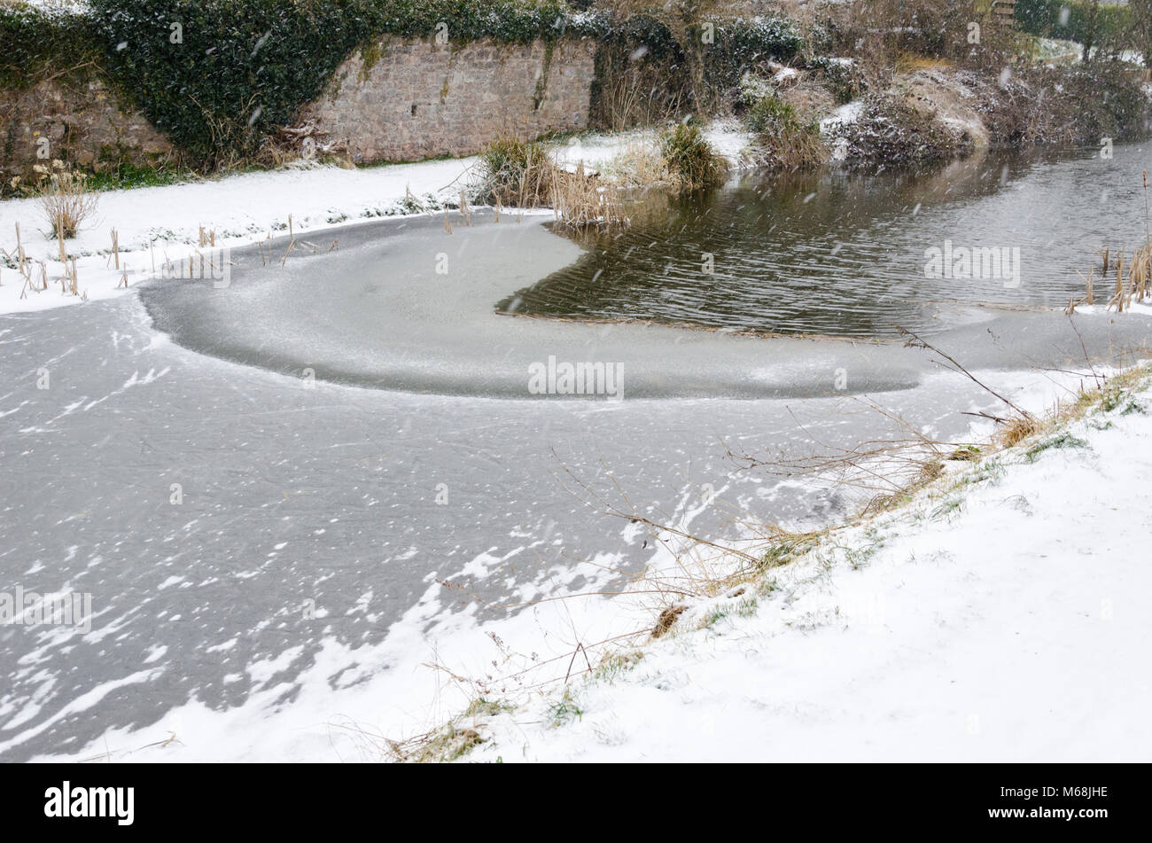 Canal water surface freezing over in cold weather. Stock Photo