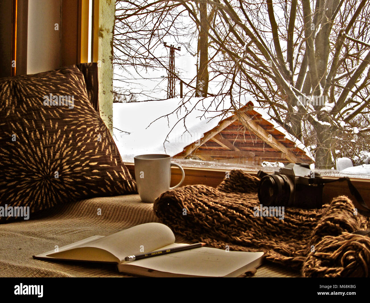 winter photography, white mug with coffee analog vintage camera and book, warm home, snow, beautiful winter day Stock Photo