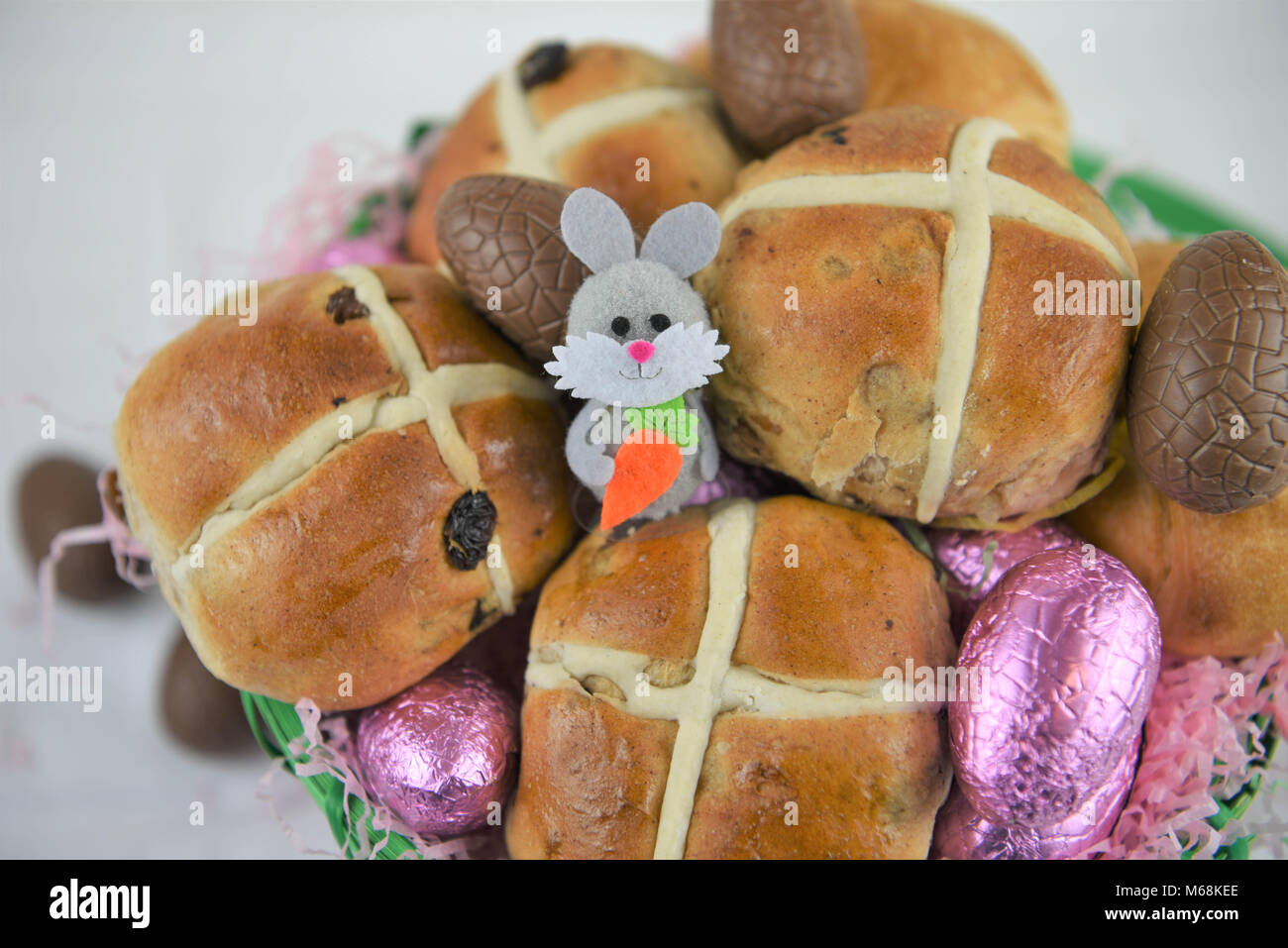 Easter food in a basket with hot cross buns and chocolate Easter ...