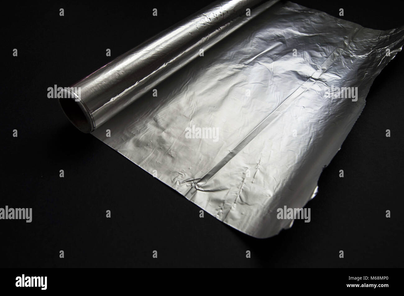 The aluminum foil used for cooking in the kitchen stands on the black