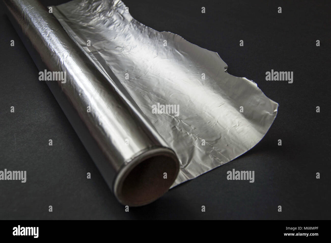 The aluminum foil used for cooking in the kitchen stands on the black