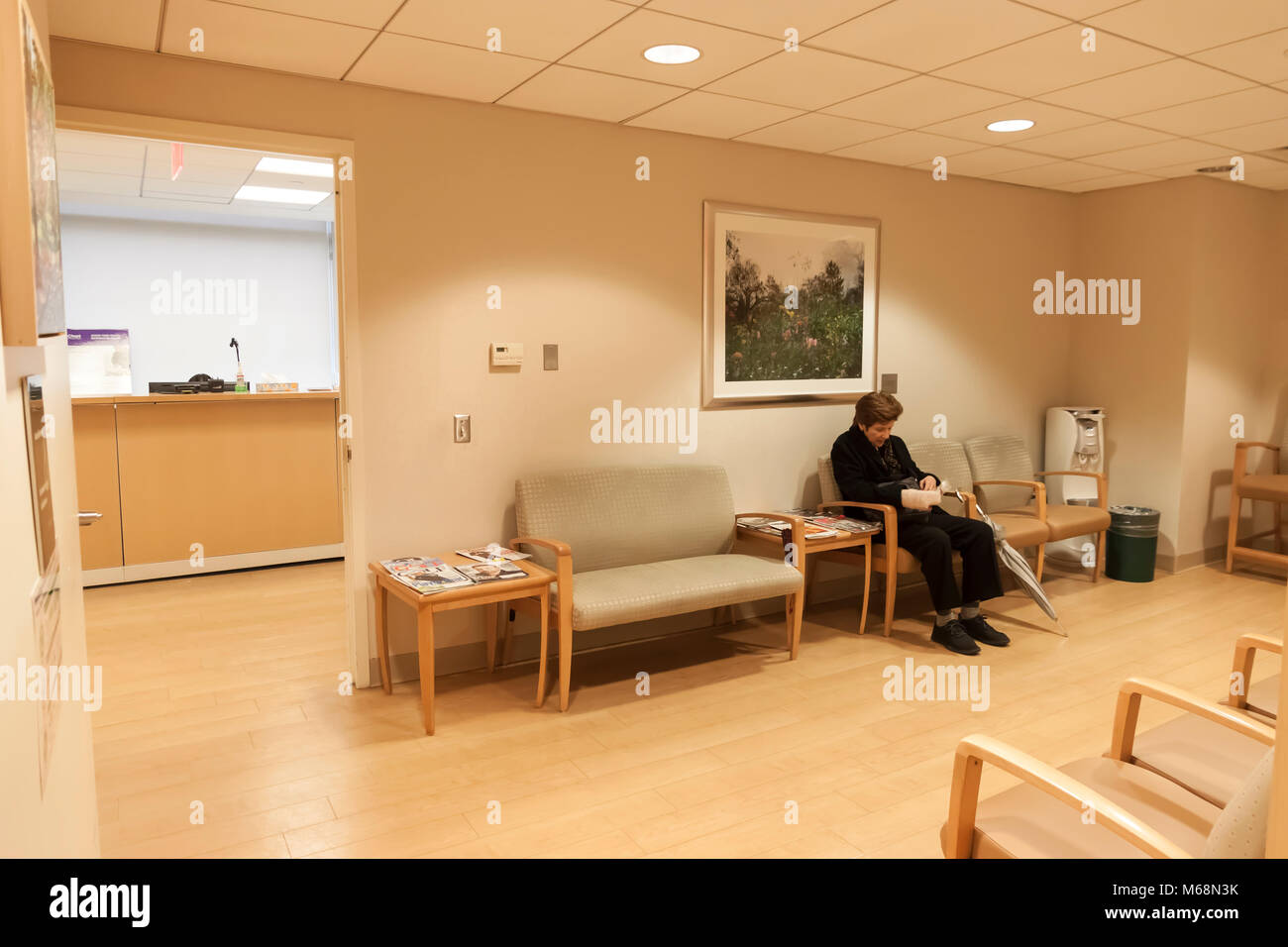 Female sitting in the waiting room of a doctor's office. Stock Photo