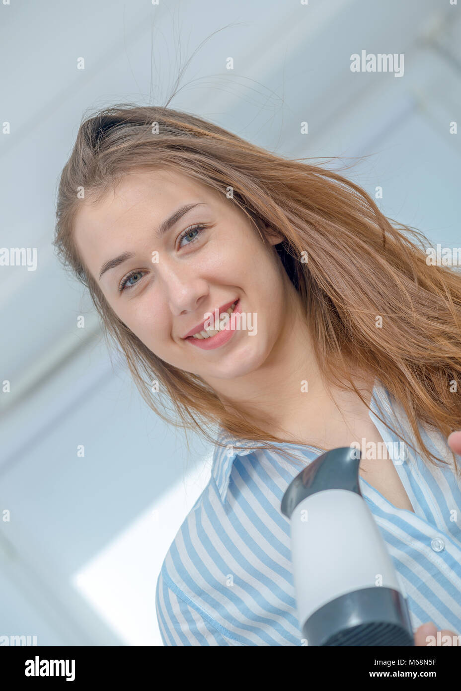 smiling pretty young woman is drying her hair Stock Photo - Alamy