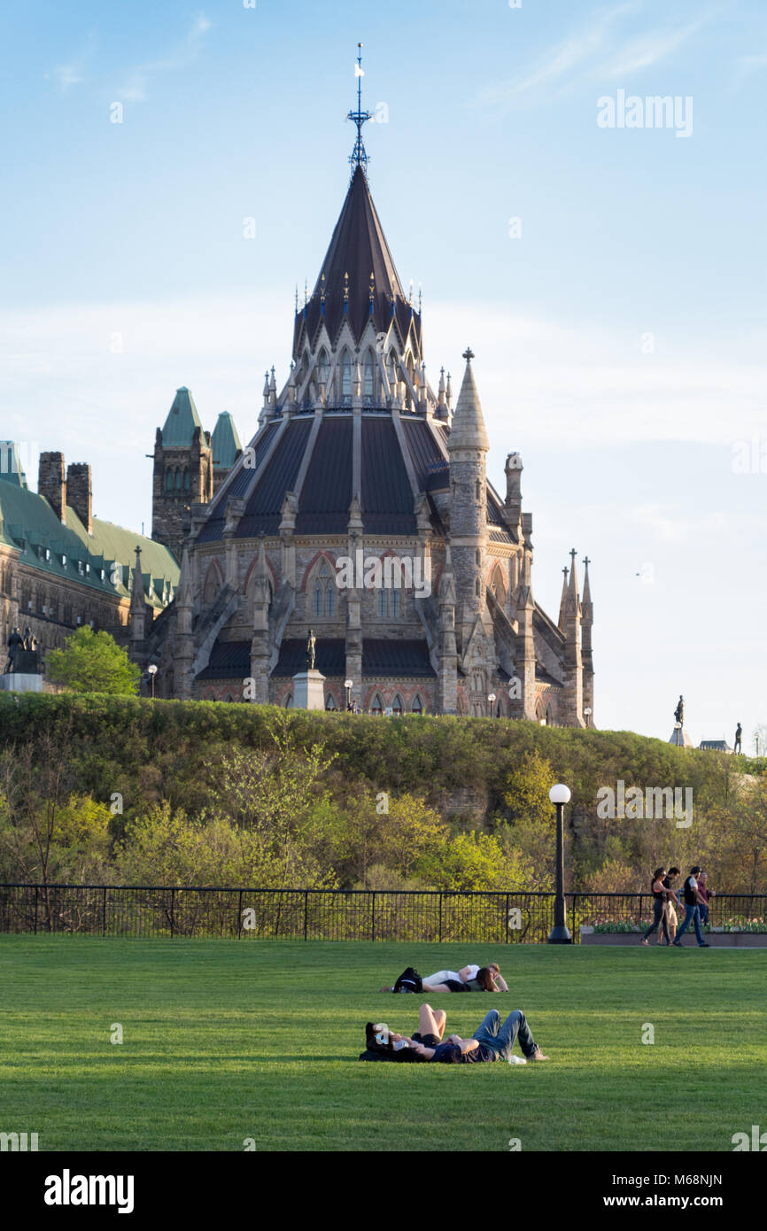 People enjoying a sunny spring day on Major's Hill Park with the Library of Parliament in the background Stock Photo