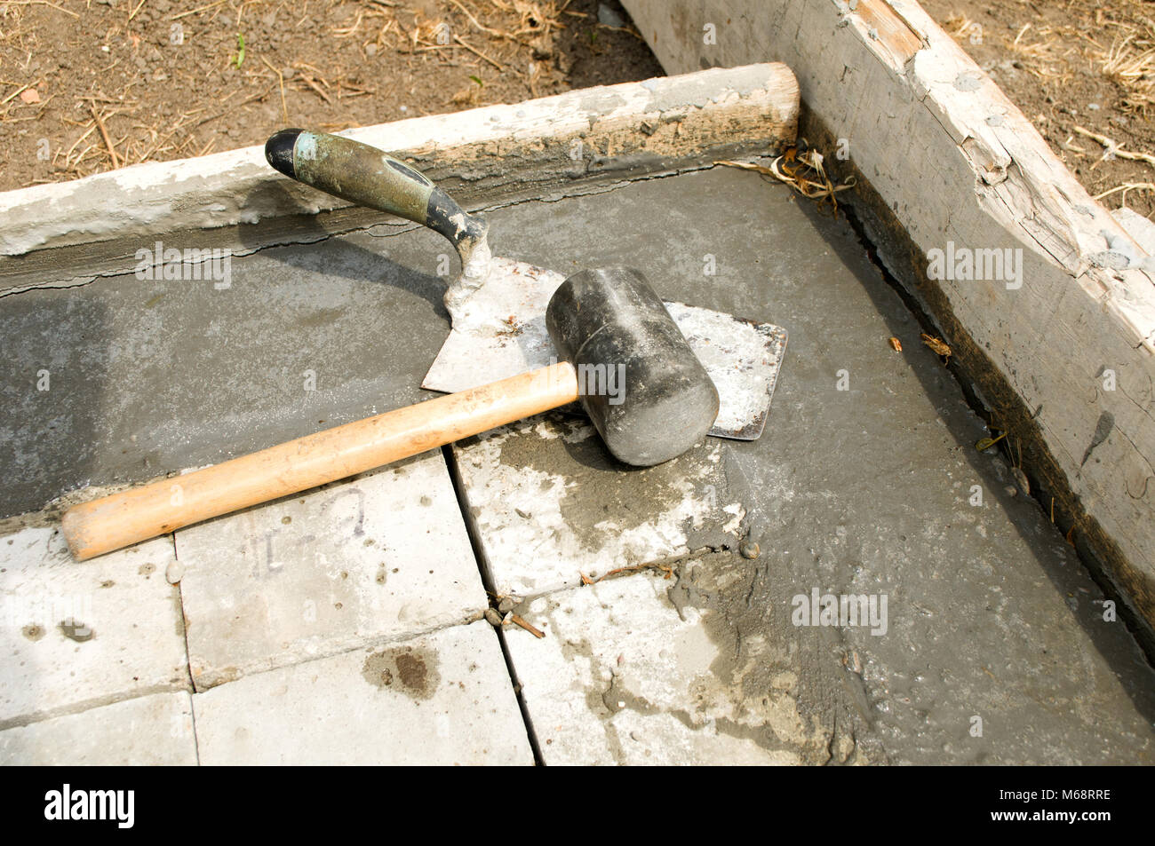 Trowel and hammer on concrete blocks Stock Photo Alamy
