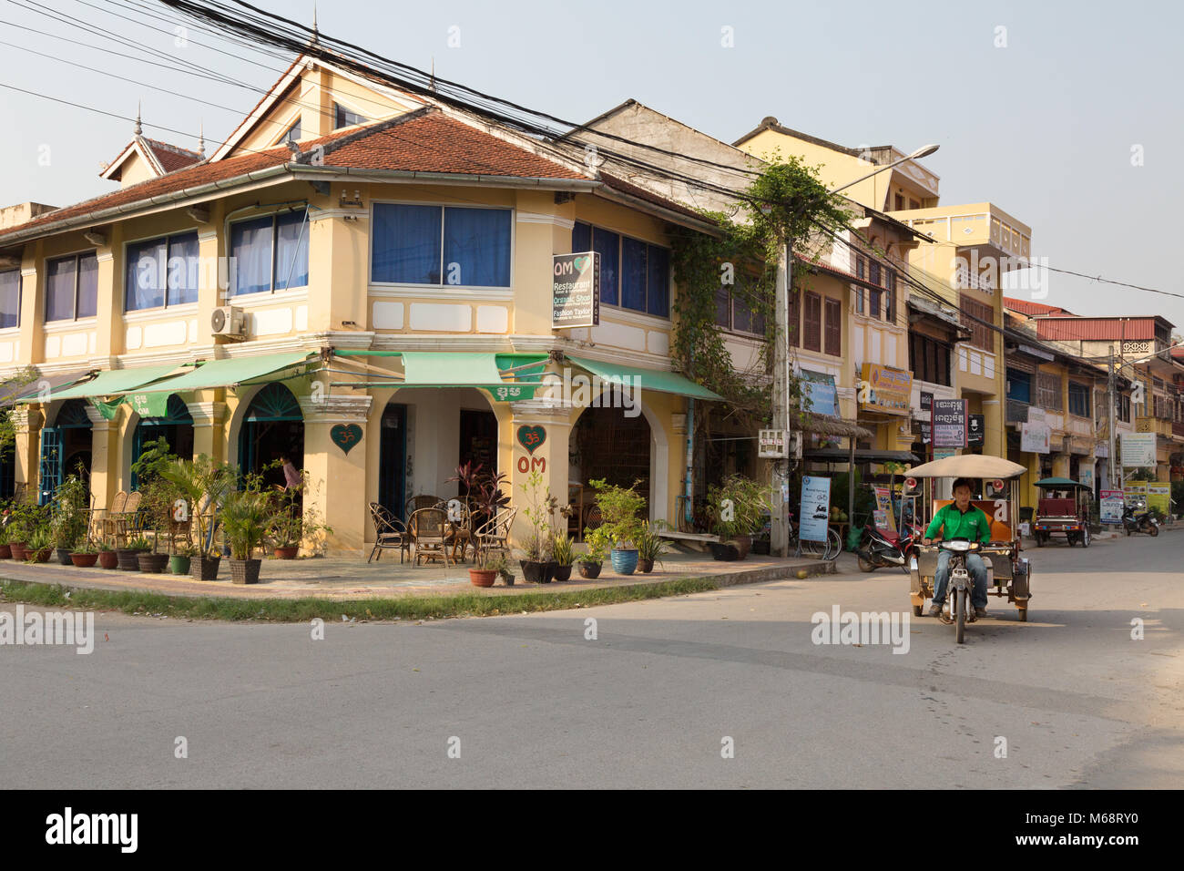 Street scene with french colonial buildings and tuk tuk, Kampot town, Cambodia Asia Stock Photo