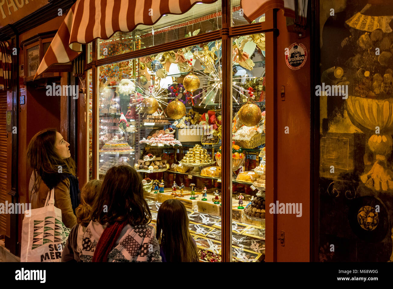 Auslage, Schaufenster eines Süßwarengeschäfts in Palma de Mallorca mit staunenden Passanten Stock Photo