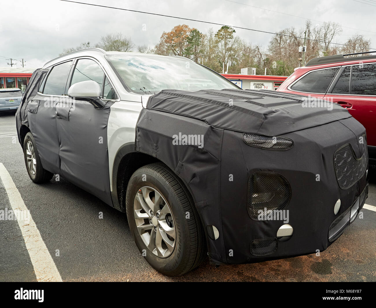 Prototype Hyundai SUV automobile or car disguised in a black vinyl  camouflaged wrap parked in a parking lot in Auburn Alabama, USA. Stock Photo