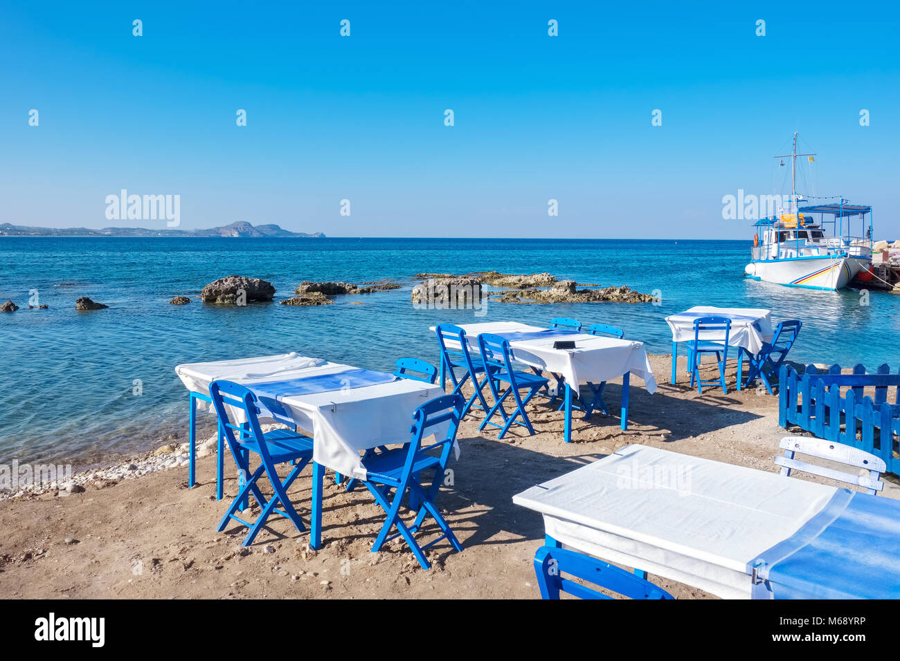 Beach with traditional blue tables and chairs. Kolymbia. Rhodes, Greece Stock Photo