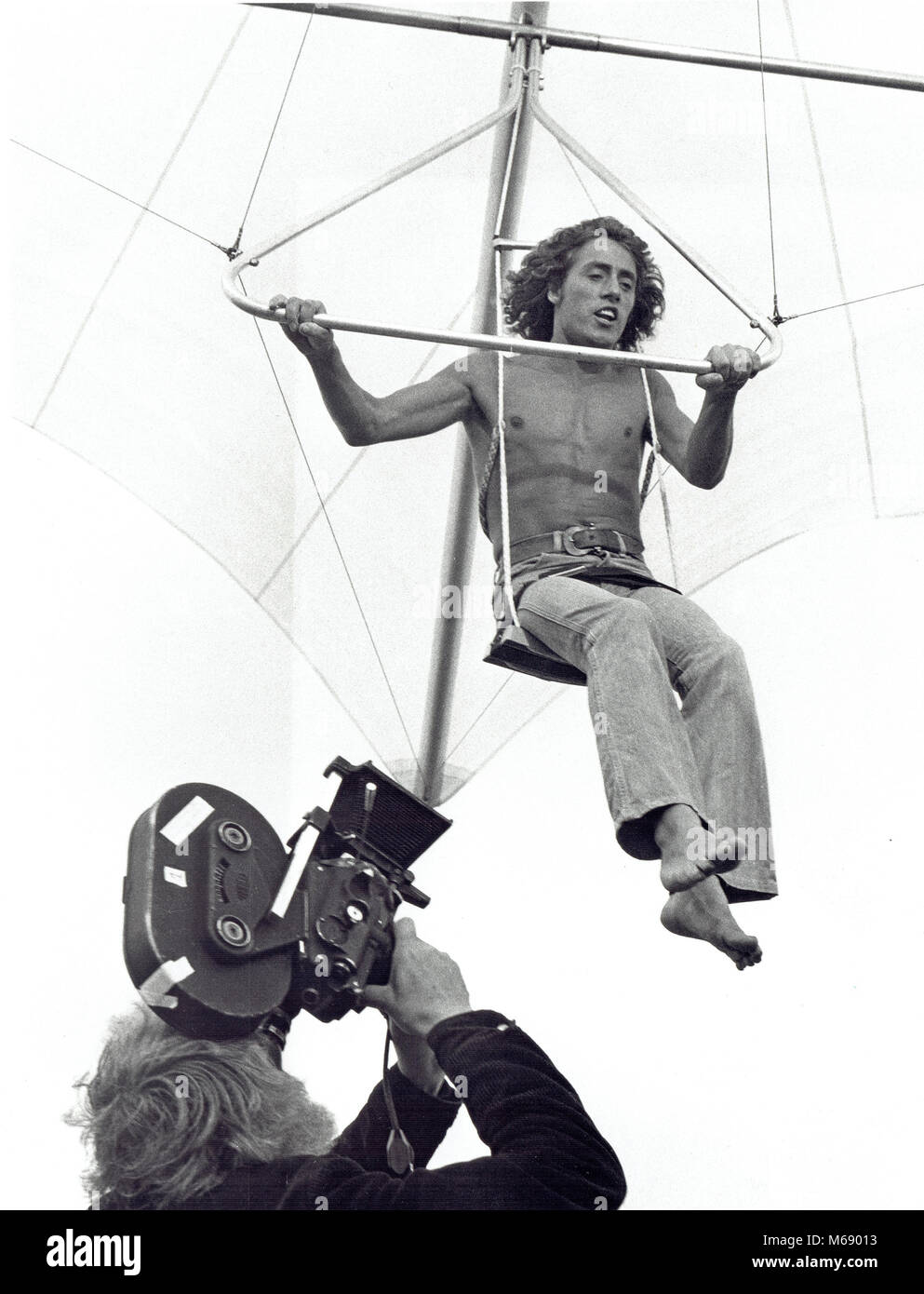 Ken Russell takes the camera filming Roger Daltrey in Tommy on the Marlborough Downs in 1974 Stock Photo