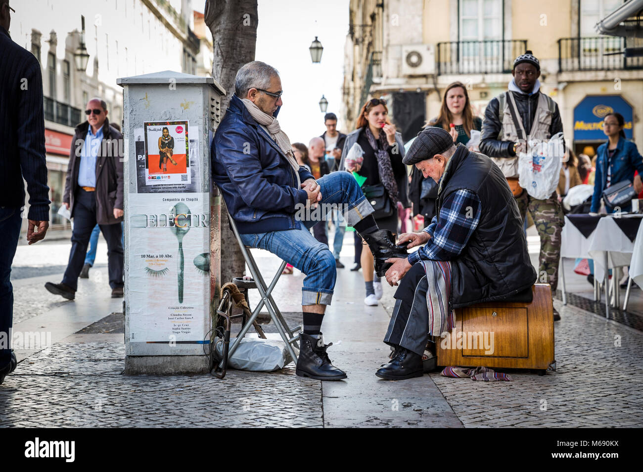A man has his shoes shined on the street in Lisbon, Portugal. Stock Photo