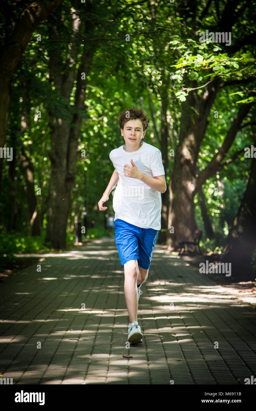 Teenage boy running in park Stock Photo
