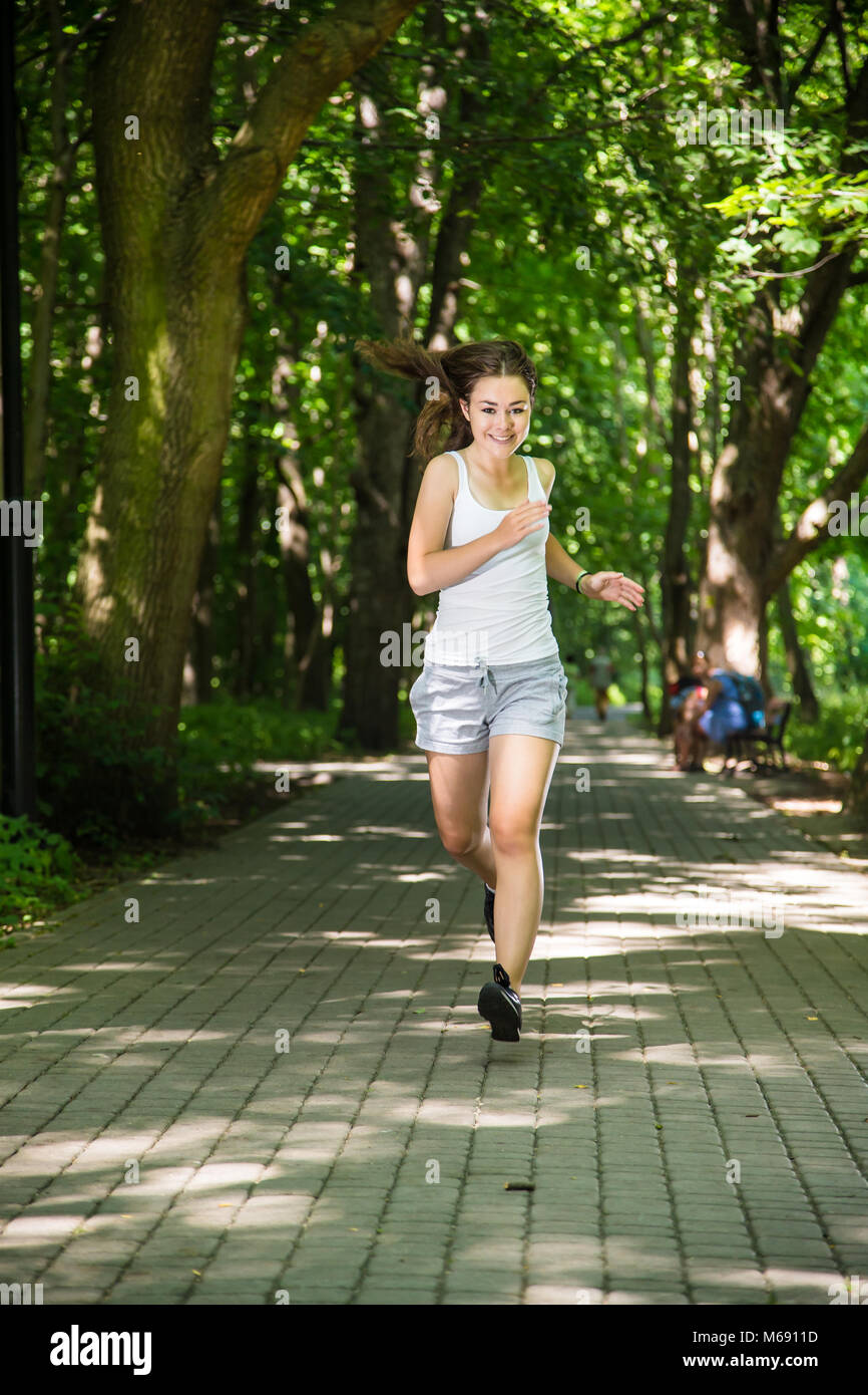 Teenage girl running, jumping in park Stock Photo