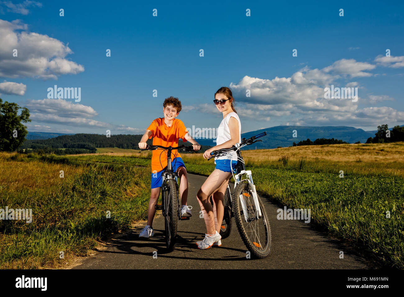 Teenage girl and boy riding bikes Stock Photo Alamy