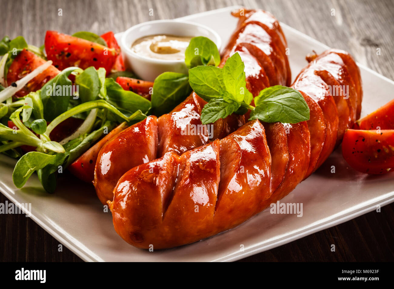 Grilled sausages on wooden table Stock Photo