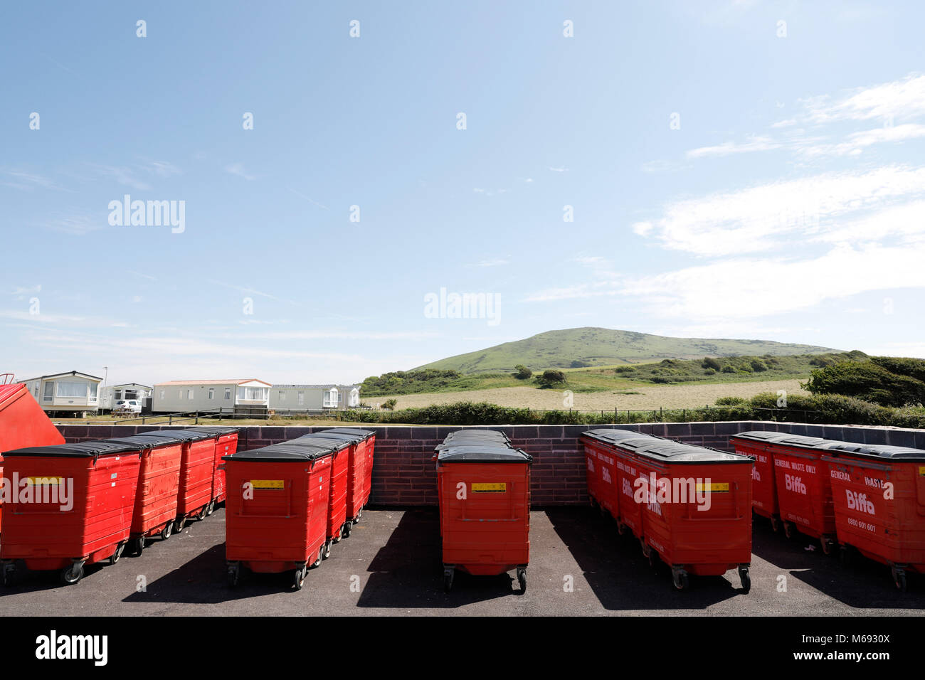 Swansea, UK. 6th Juy, 2017.  Red refuse collection skips, otherwise known as wheely bins, at Broughton Farm Caravan Park, Gower peninsula, Swansea. Stock Photo