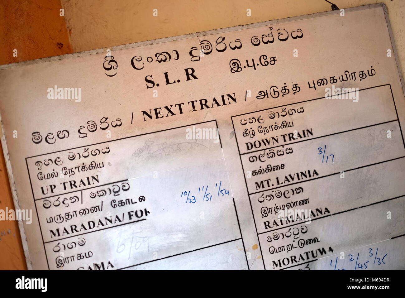 A sign showing train times at Mount Lavinia station near Colombo in Sri Lanka Stock Photo