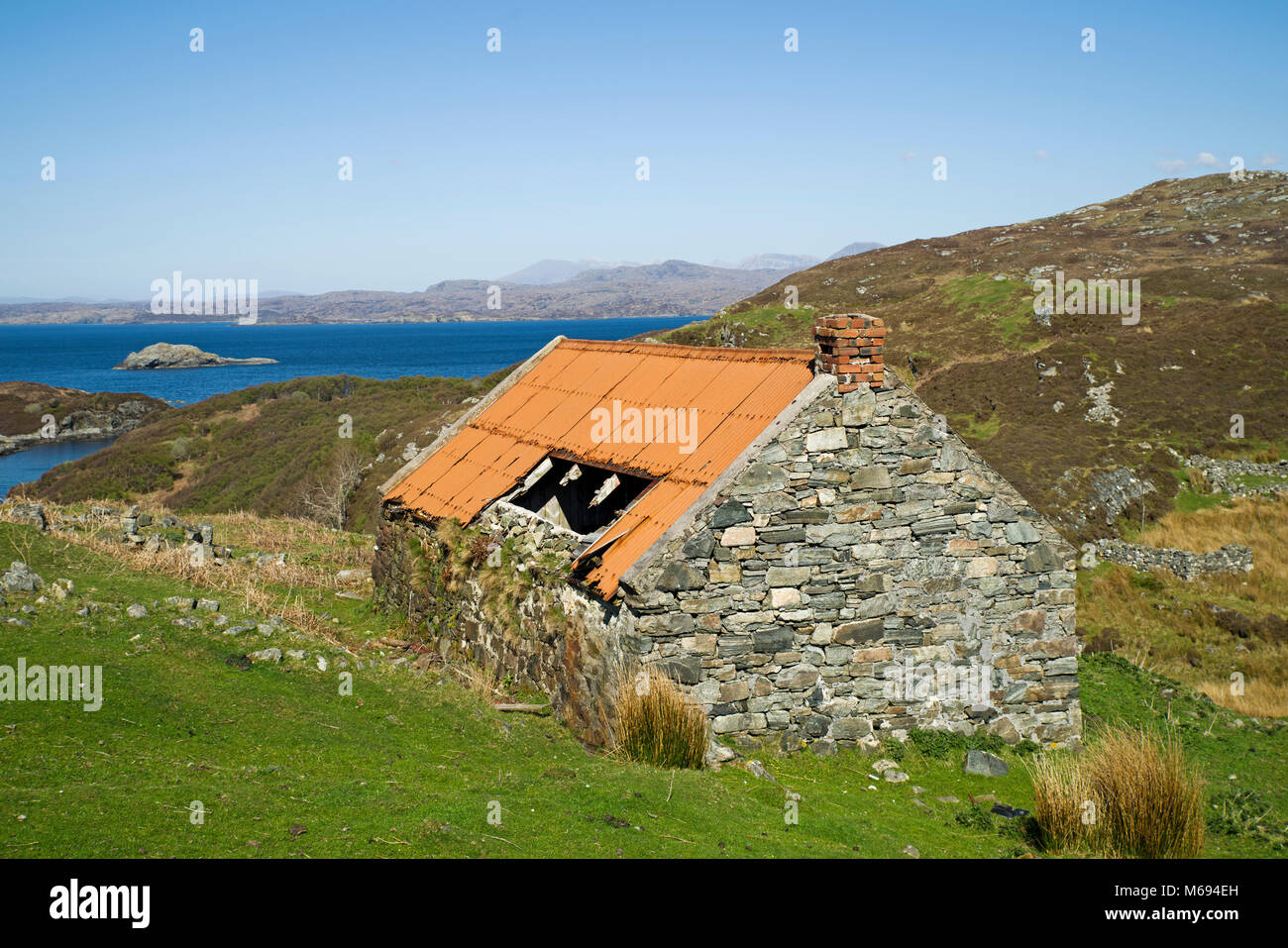 Old derelict abandoned croft house with corrugated iron roof at the coastal settlement of Drumbeg, Assynt, Sutherland, Scottish Highlands, Scotland UK Stock Photo