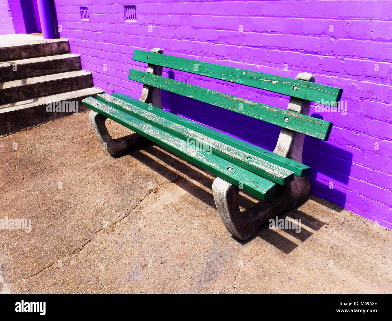 Bench seat contrasting against vibrant coloured wall Stock Photo