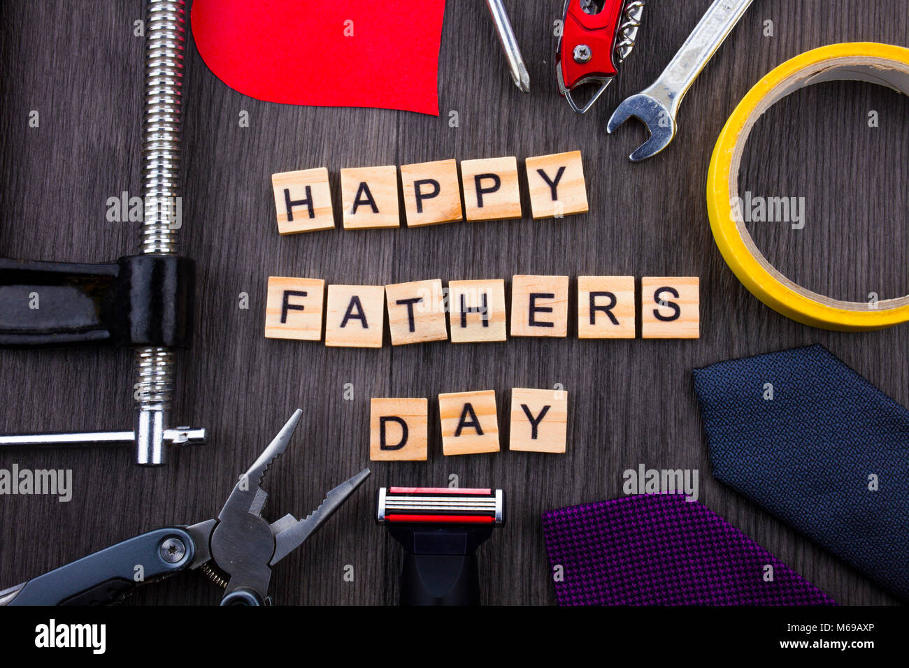 Happy Fathers Day message on a wooden background with frame of tools and ties. Stock Photo