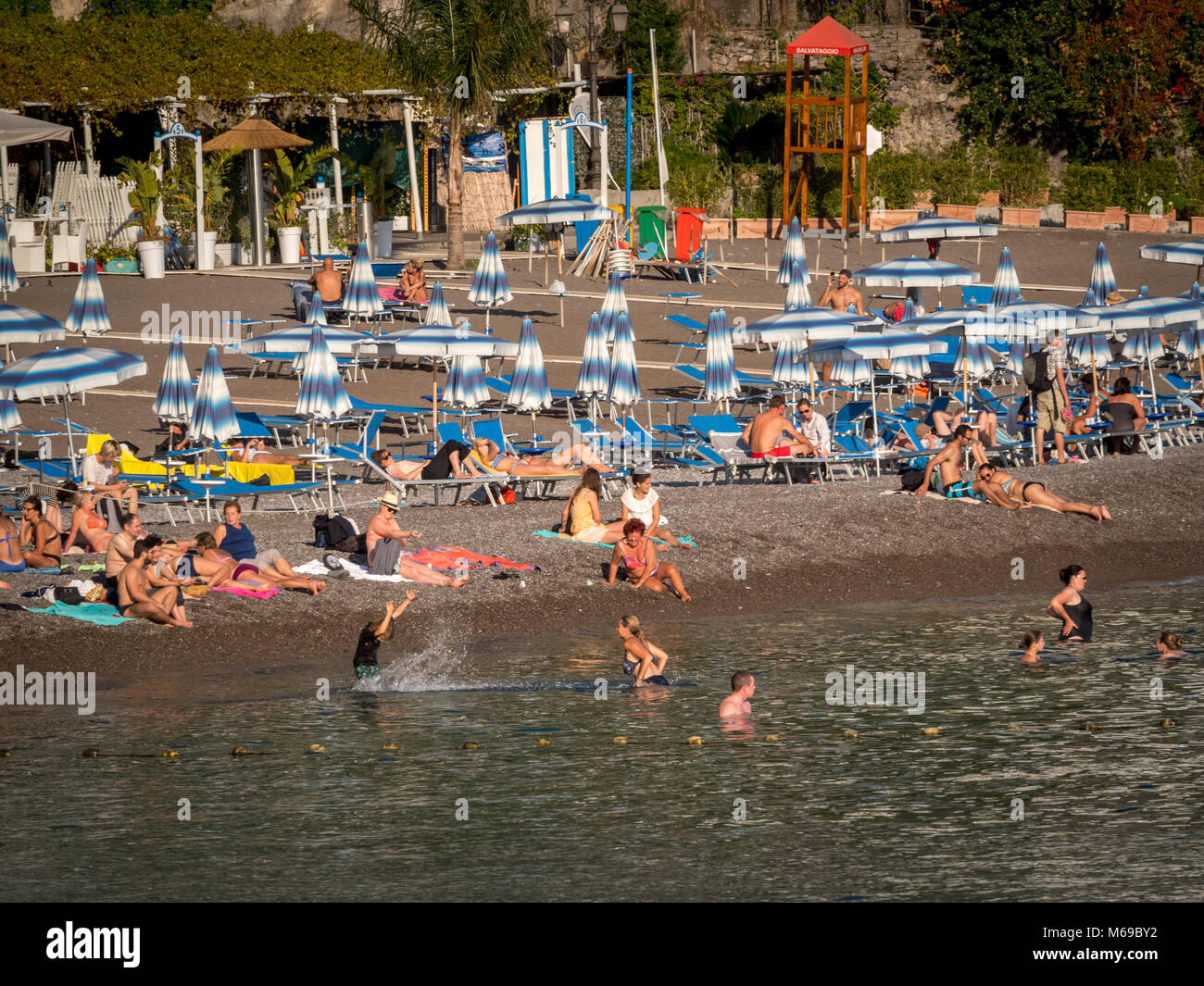 Holidaymakers in sea and on beach, Positano, Amalfi Coast, Italy. Stock Photo