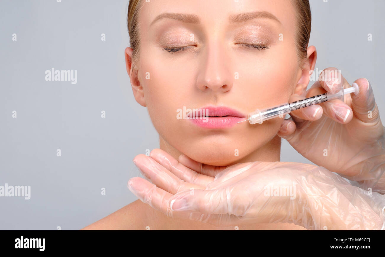 Woman is getting botox injection in lips. Cosmetic Treatment. Plastic
