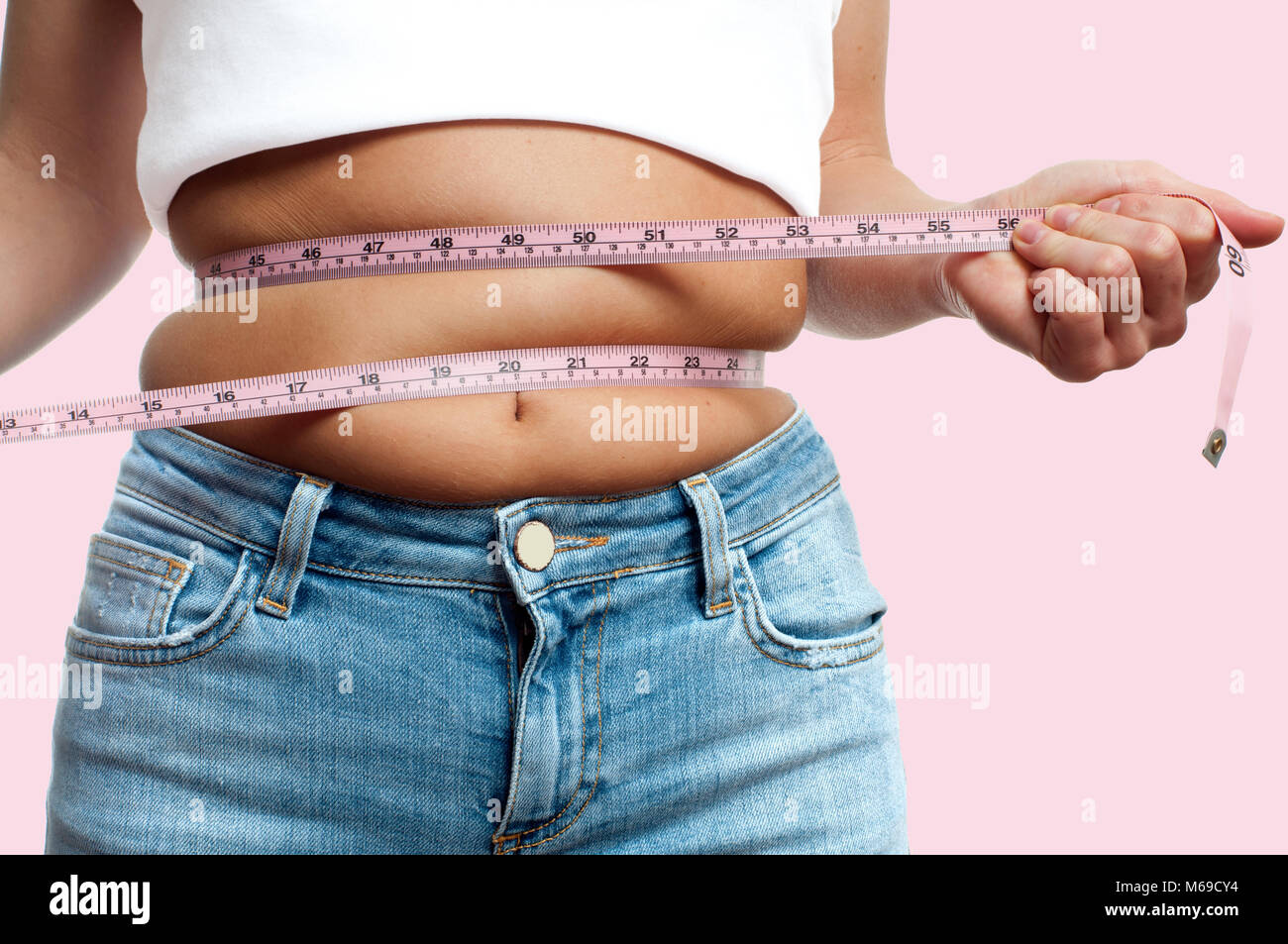 https://c8.alamy.com/comp/M69CY4/overweight-woman-with-tape-measure-around-waist-on-pastel-pink-background-M69CY4.jpg