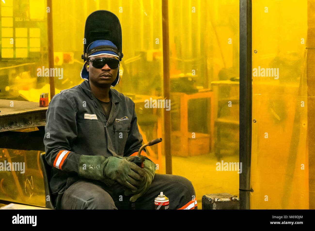 African tradesman working with a welding torch in a training workshop Stock Photo