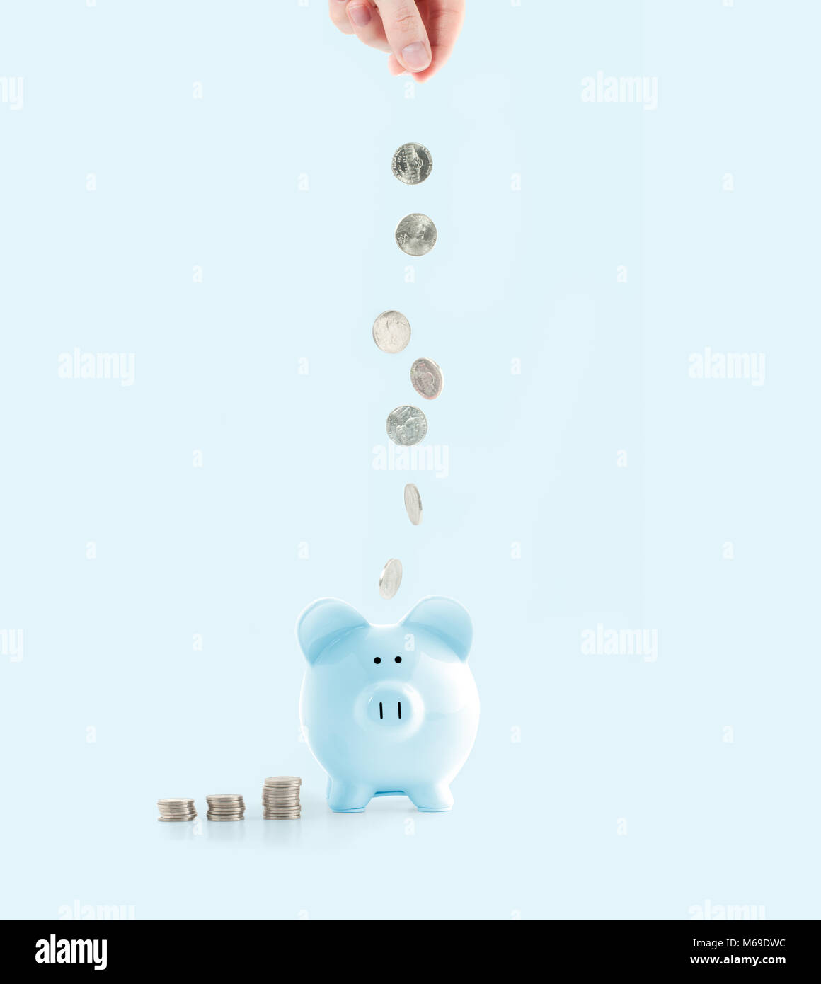 Savings concept. Female hand putting coin into piggy bank on pastel ...