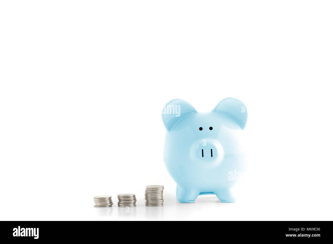 Front view. Blue piggy bank and coins isolated on white Stock Photo - Alamy