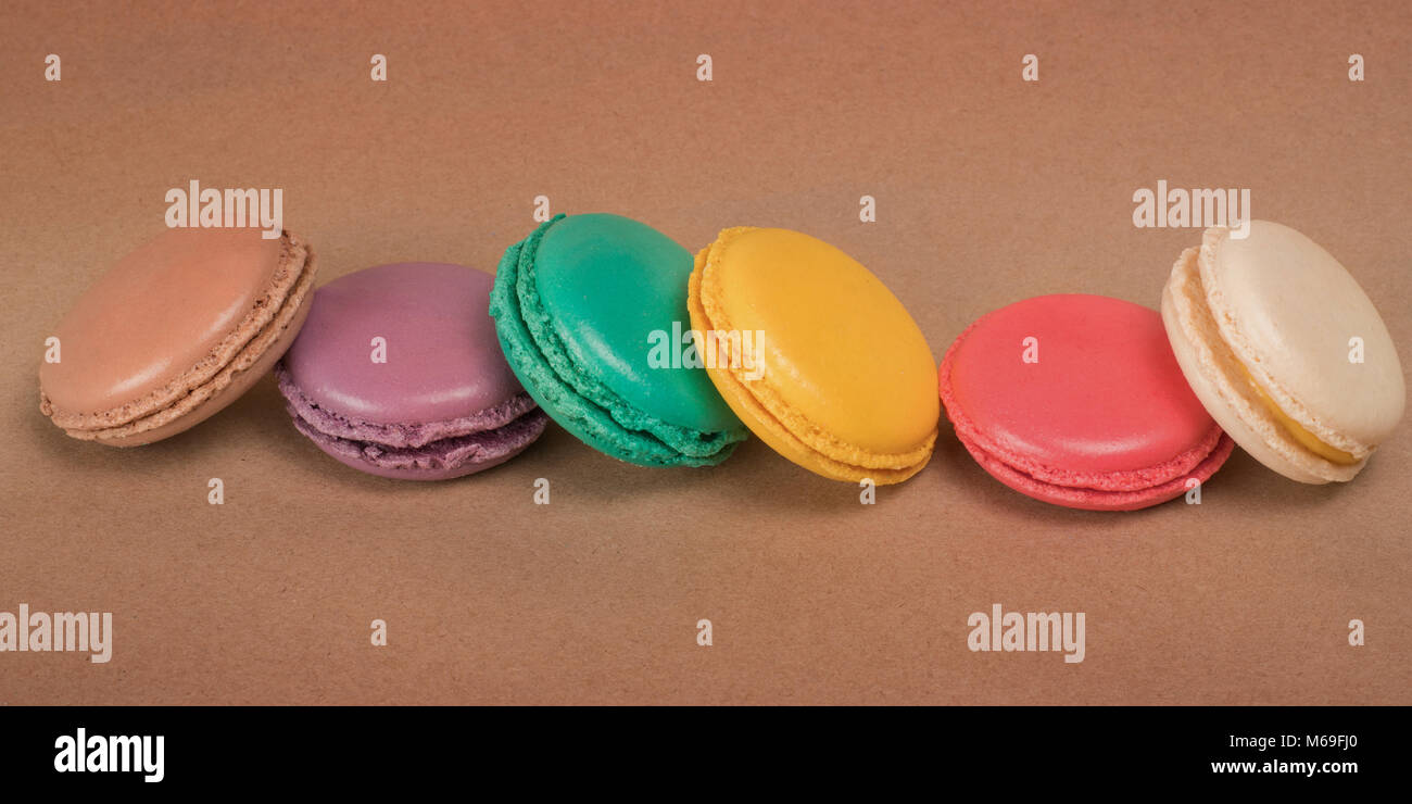 Row Of Bright Colored Macaroons On Craft Paper Background Stock Photo Alamy