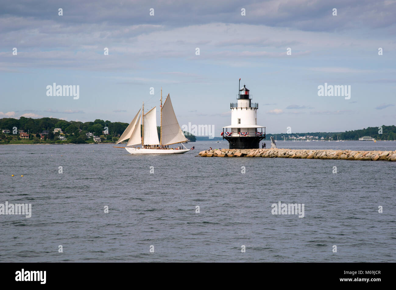 An authentic schooner, referred to as a windjammer, sails past Spring Point Lighthouse in Portland, Maine. Stock Photo