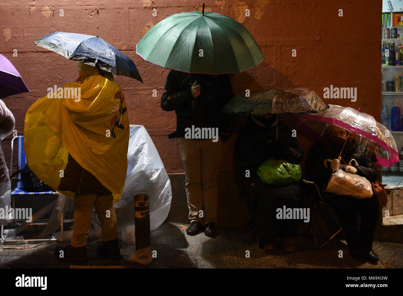 Madrid, Spain. 01st Mar, 2018. Catholic faithful use umbrellas in a street of Madrid as they wait, some for as long as fifteen days, to kiss the feet of a 17th Century wooden image of Christ, known as Cristo de Medinaceli. Credit: Jorge Sanz/Pacific Press/Alamy Live News Stock Photo