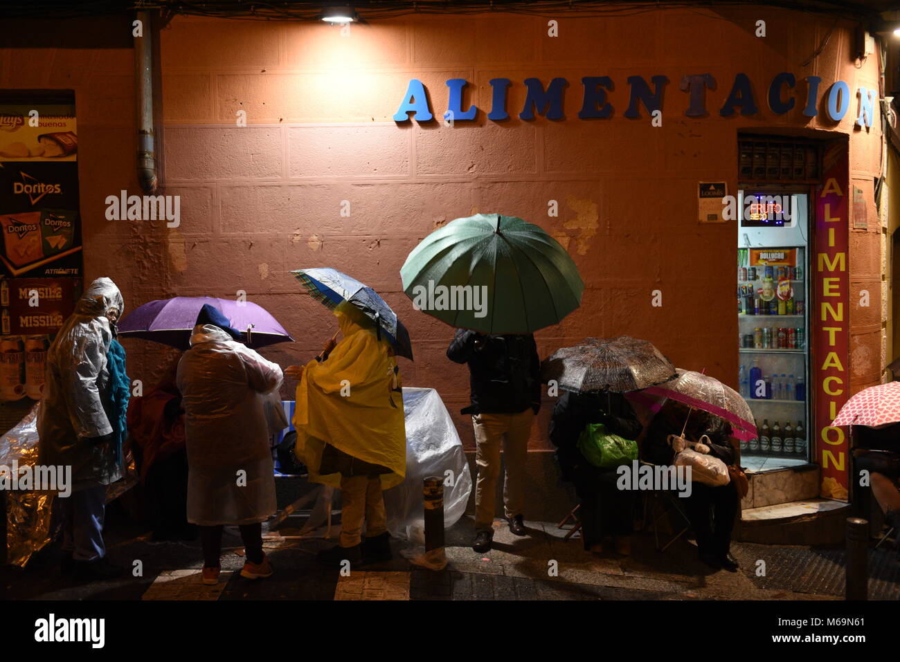 Madrid, Spain. 01st Mar, 2018. Catholic faithful use umbrellas in a street of Madrid as they wait, some for as long as fifteen days, to kiss the feet of a 17th Century wooden image of Christ, known as Cristo de Medinaceli. Credit: Jorge Sanz/Pacific Press/Alamy Live News Stock Photo