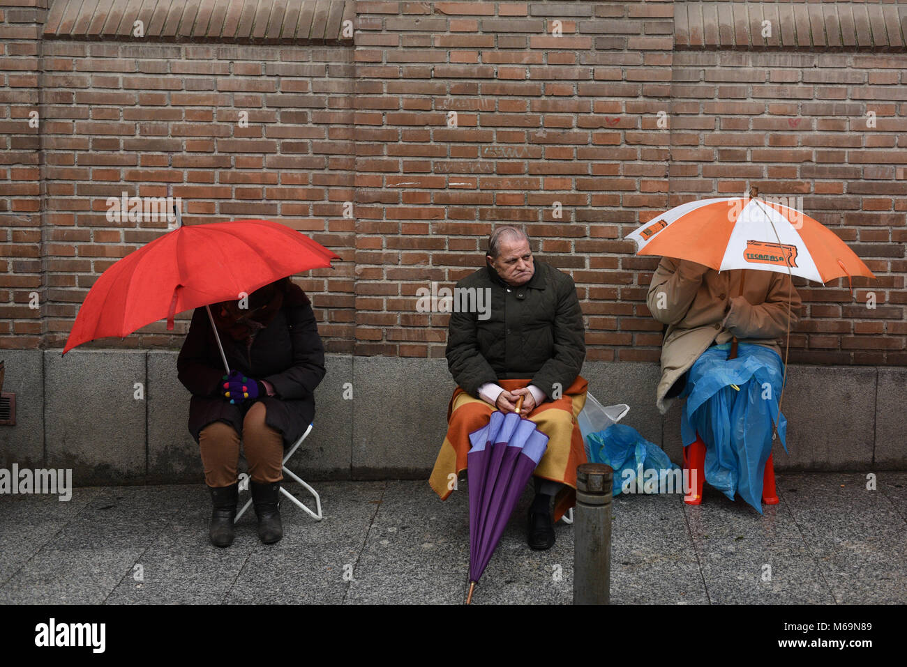 Madrid, Spain. 01st Mar, 2018. Catholic faithful use umbrellas in a street of Madrid as they wait, some for as long as fifteen days, to kiss the feet of a 17th Century wooden image of Christ, known as Cristo de Medinaceli. Credit: Jorge Sanz/Pacific Press/Alamy Live News Stock Photo