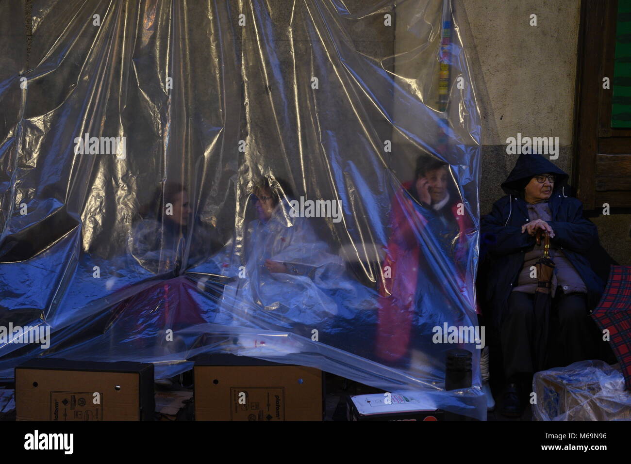 Madrid, Spain. 01st Mar, 2018. Catholic faithful protect themselves from the rain with a plastic as they wait in a street of Madrid to kiss the feet of a 17th Century wooden image of Christ, known as Cristo de Medinaceli. Credit: Jorge Sanz/Pacific Press/Alamy Live News Stock Photo