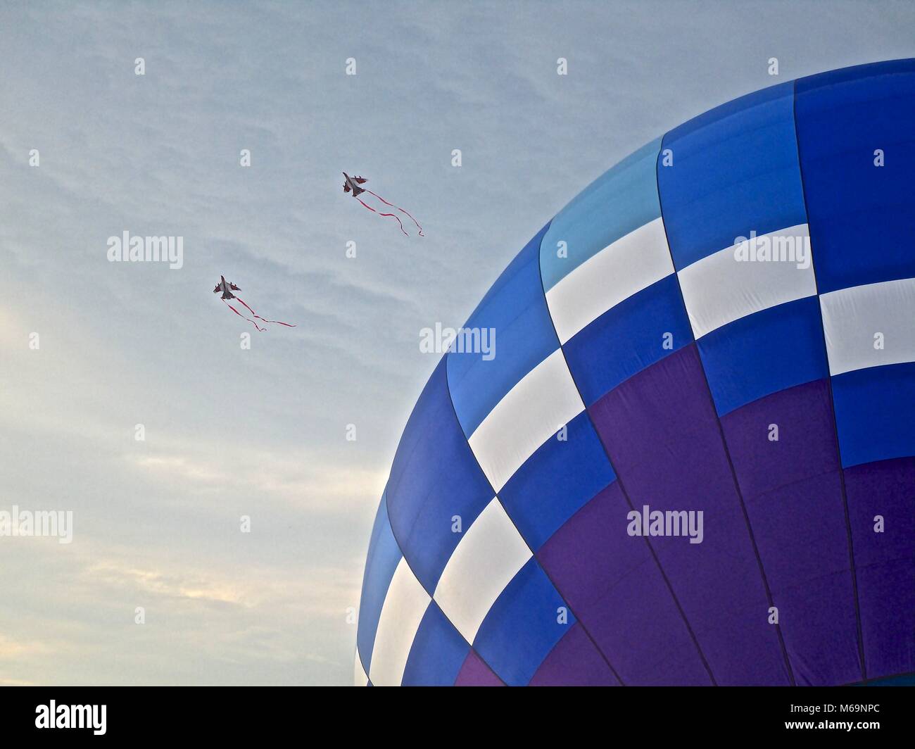 Blue and purple hot air balloon with two kites in the shape of fighter