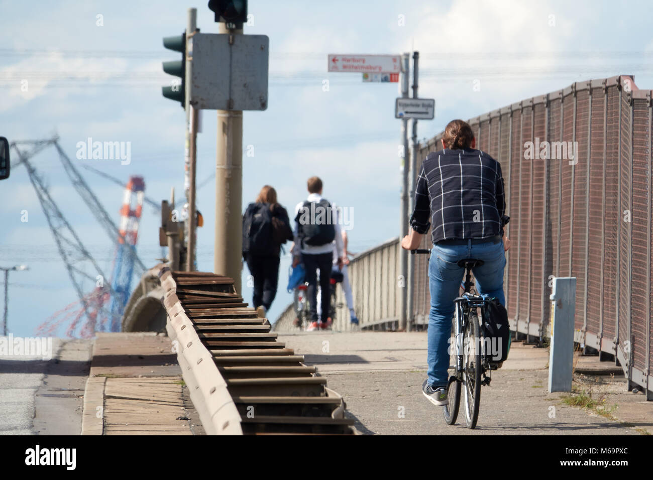 A guy in a shirt and blue jeans is riding a road bike to work on a summer sunny day. Stock Photo