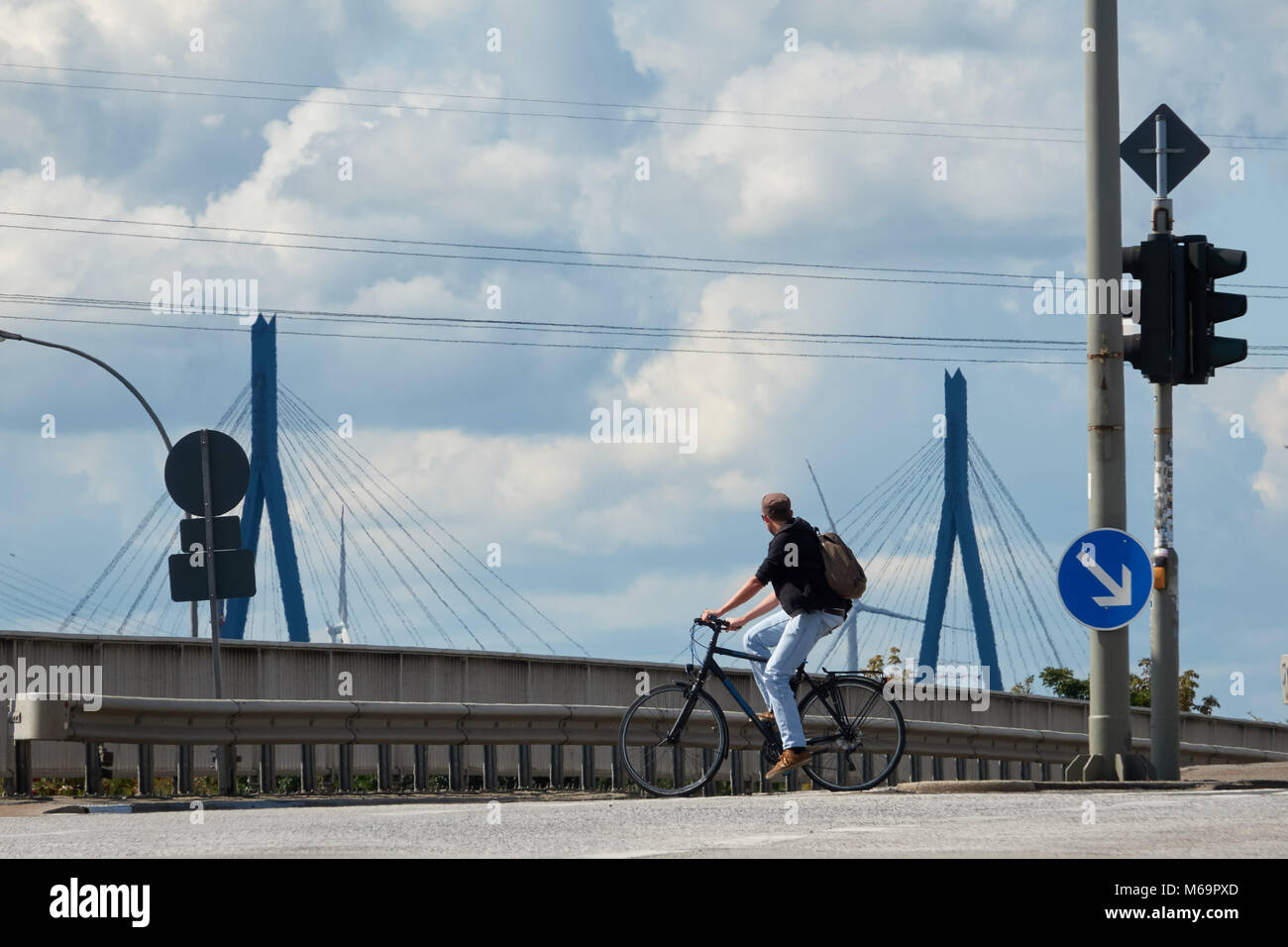 A guy in a shirt and blue jeans is riding a road bike to work on a summer sunny day. Stock Photo