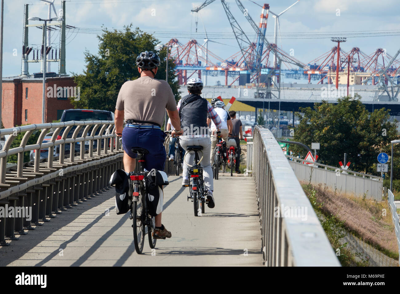 Group of tourists on bicycles go to the seaport of Hamurgh. Stock Photo