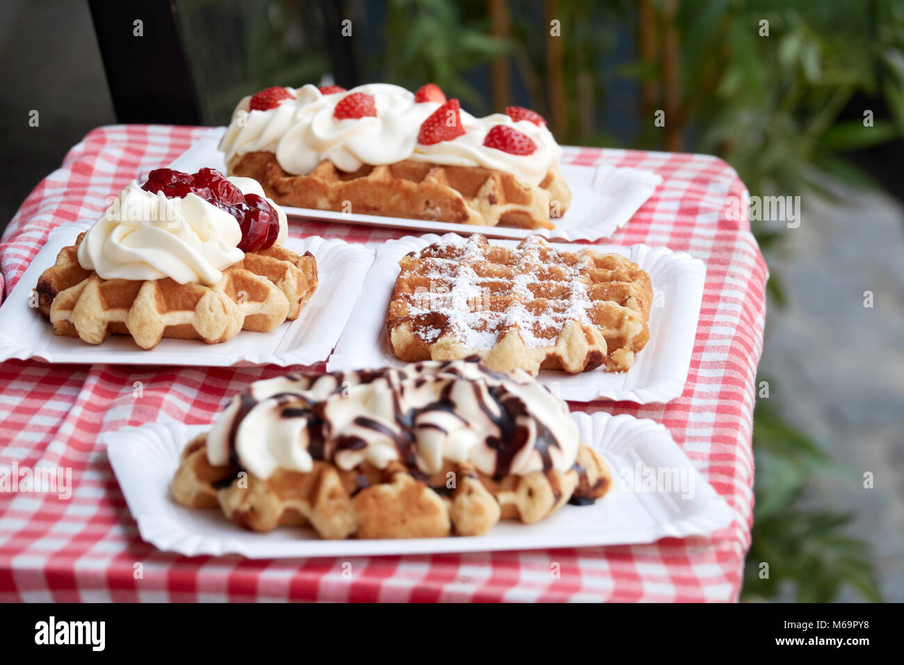 Popular national dish Belgian waffles with strawberries, cherries, chocolate and powder in the tourist town of Bruges. Stock Photo