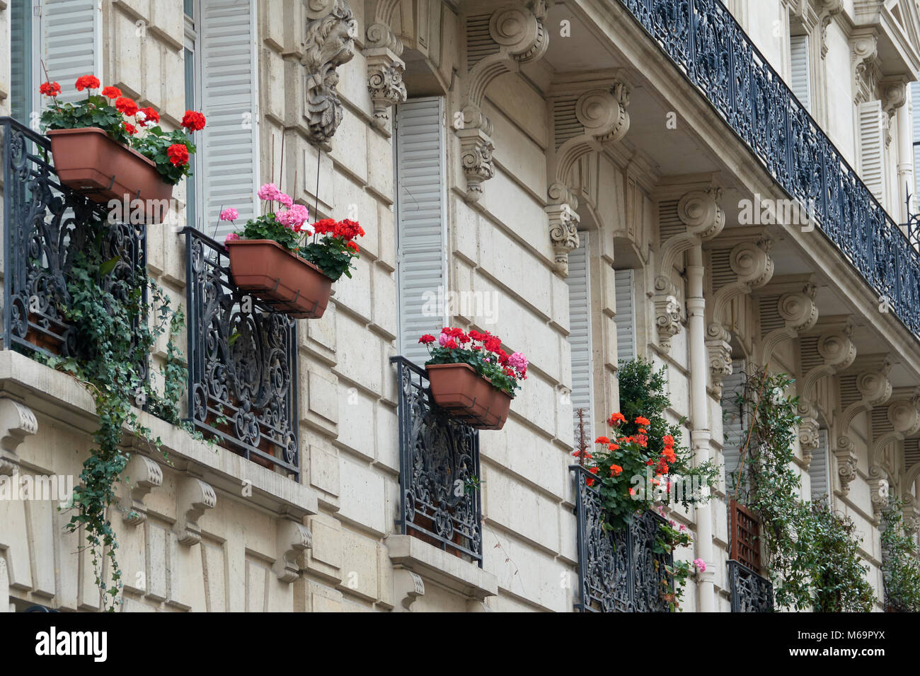 Beautiful European facade of the building is decorated with flower pots. Stock Photo