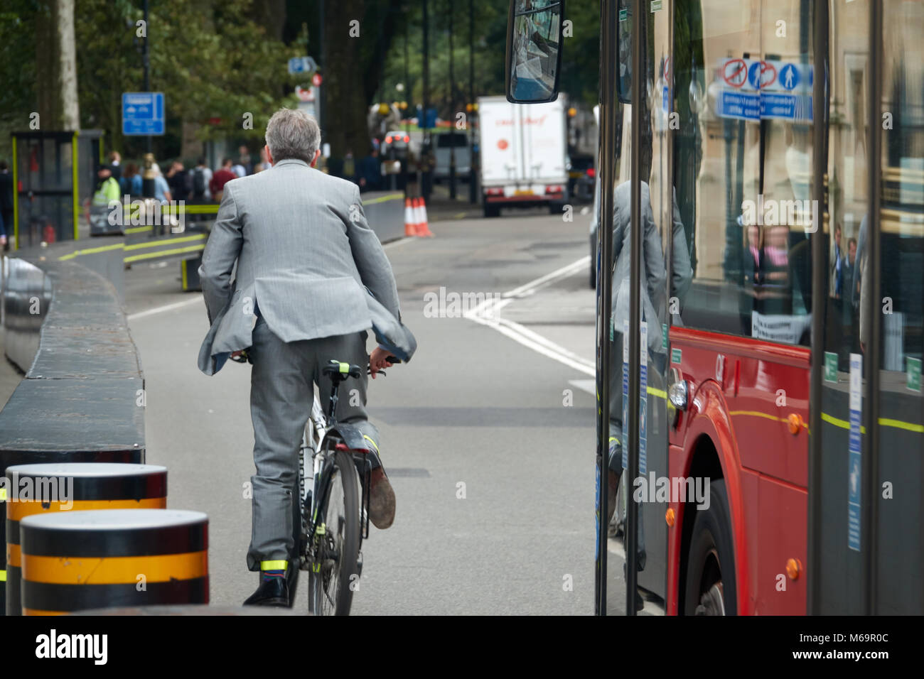 A businessman in a business suit rides a bike through the streets of London. Stock Photo