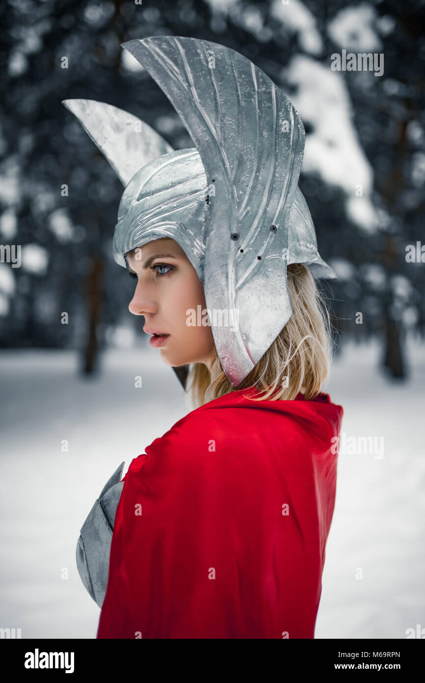 Portrain of woman in image of Germanic-Scandinavian God of thunder and storm against winter forest background. Stock Photo