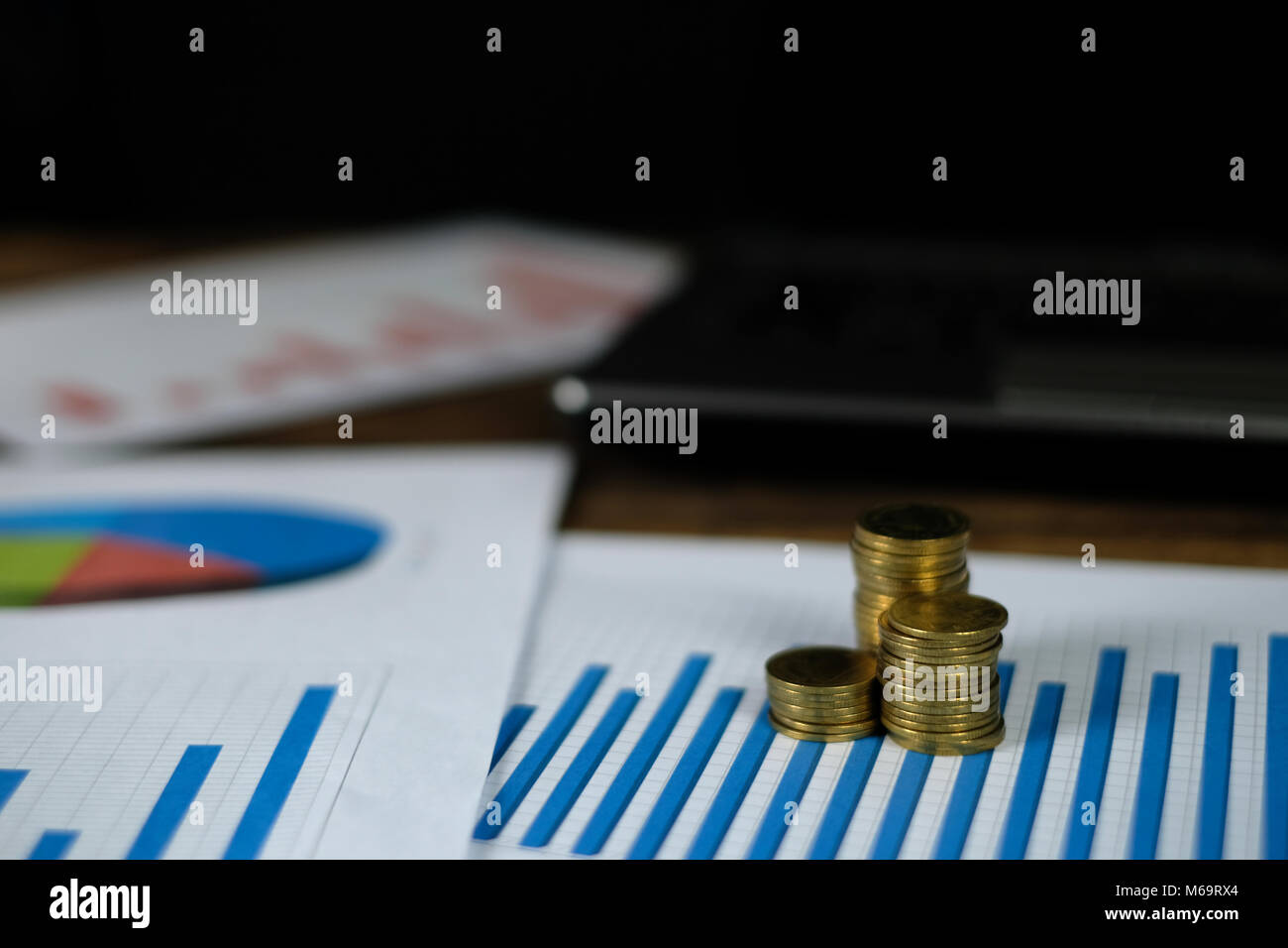 Step of coins stacks with notebook laptop computer and financial graph ...