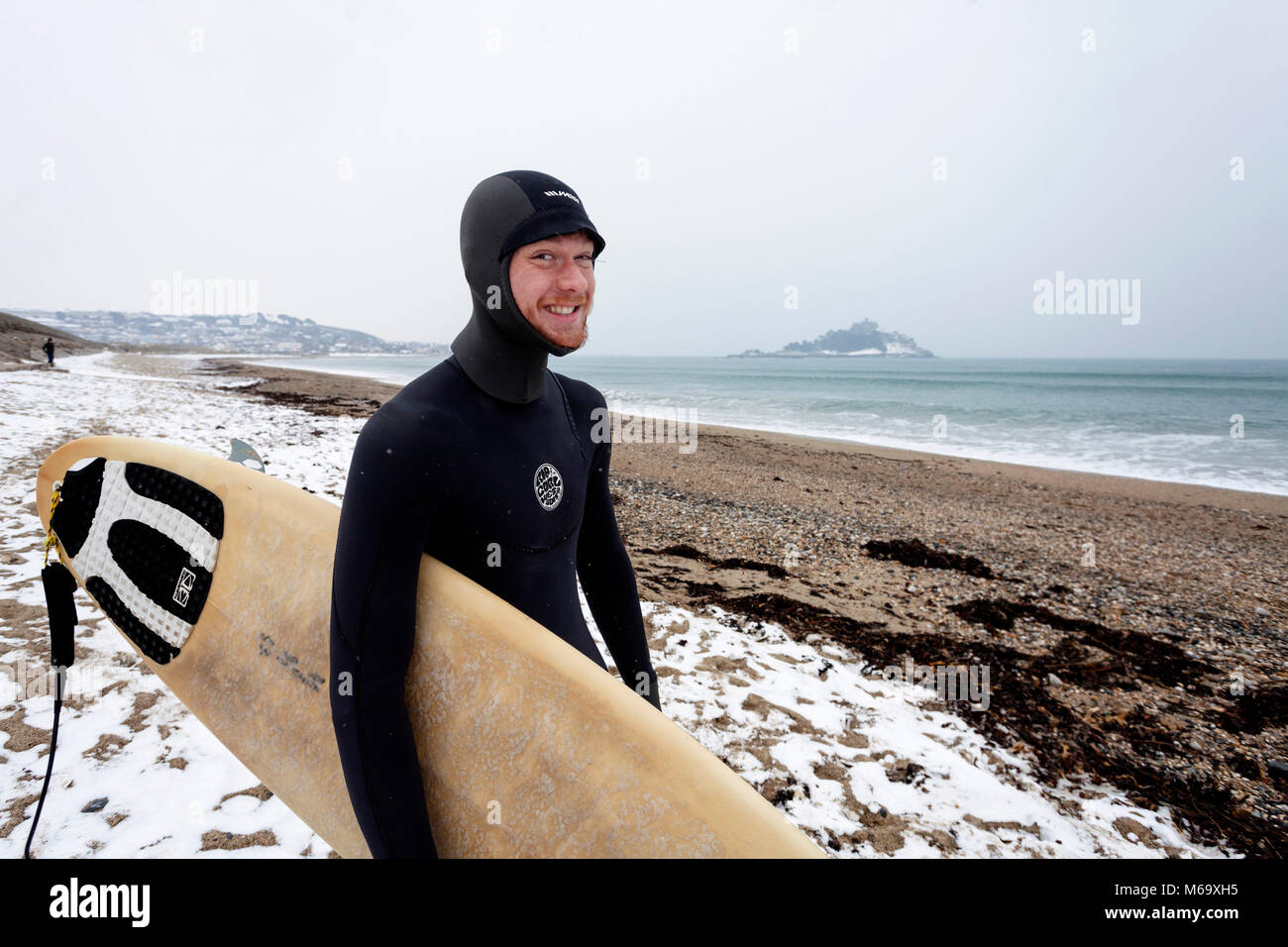 Marazion, Cornwall. 1st Mar, 2018. UK Weather. Marazion, Cornwall UK. 20 year old Brad Morris goes for a sub-zero surf at St Michael's Mount, Marazion, during the Beast from the East phenomenon.  Credit Mike Newman/AlamyLiveNews Stock Photo