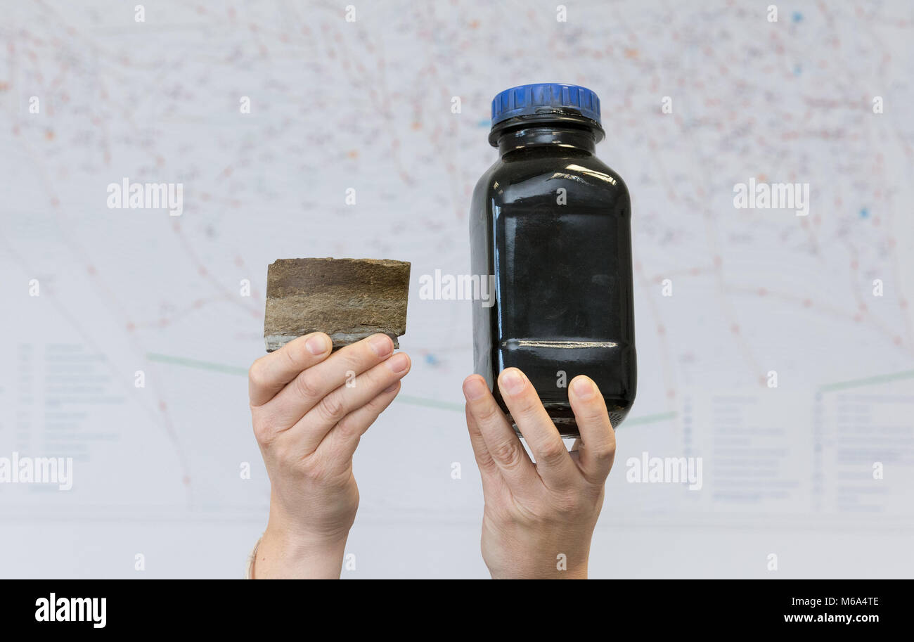 08 February 2018, Germany, Emlichheim: A pair of hands holds a drill core (L) and a small bottle of crude oil. For more than 70 years oil production has been running in the county of Bentheim. Oil producer Wintershall is counting on seismic readings to detect undiscovered oil fields. Photo: Friso Gentsch/dpa Stock Photo